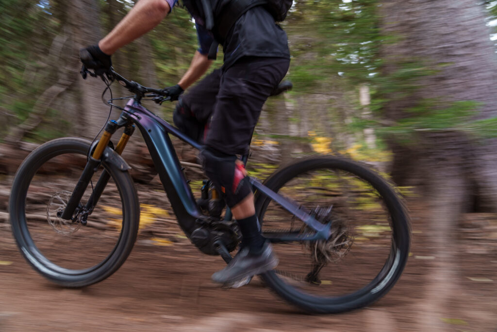 A close up shot of a giant e-mtb being ridden past the camera with motion blur