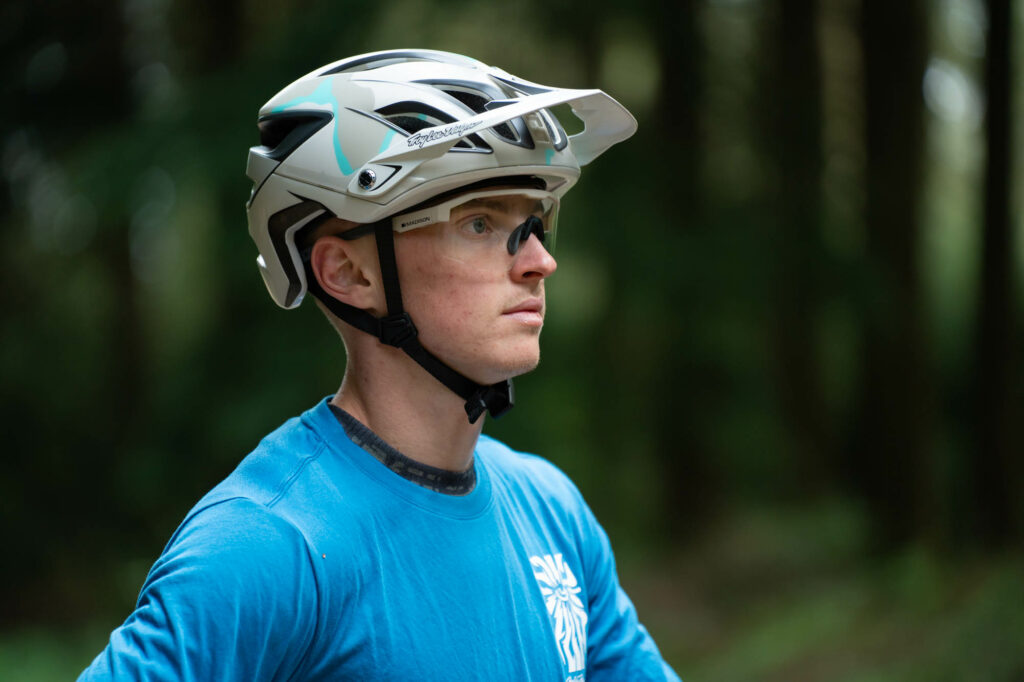 MTB rider wearing Troy Lee Designs A3 MTB Helmet looks off into the distance