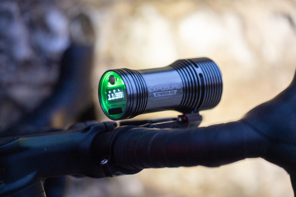Exposure Lights Strada MK13 RS on road bike handlebars with green light illuminating the display